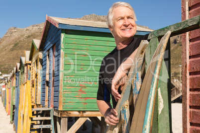 Man looking away while standing against beach huts