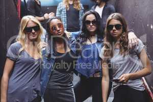 Portrait of female friends wearing sunglasses while staning together