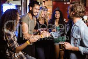 Cheerful friends at counter in nightclub