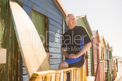 Close up of senior man looking away while sitting on railing