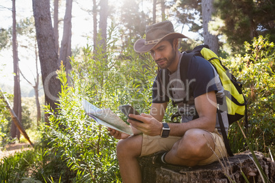 Man using mobile phone while holding the map
