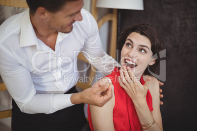 Man offering engagement ring to surprised woman