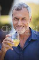 Portrait of mature man having a glass of juice