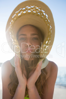 Portrait of young woman wearing sun hat at beach
