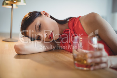 Portrait of tensed woman having a glass of whisky