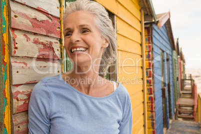 Close up of smiling senior woman standing by wall