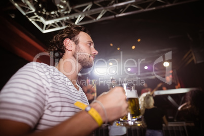 Low angle view of thoughtful man holding beer mug