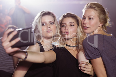 Young female friends taking selfie at nightclub