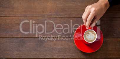 Woman holding cup of coffee on table