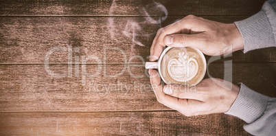 Man holding white coffee cup