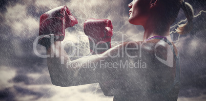 Composite image of side view of female boxer with fighting stance