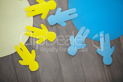 Blue and yellow paper cut out figures on table