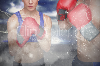 Composite image of portrait of man and woman wearing boxing gloves
