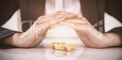 Businesswoman protecting toy car