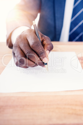 Mid section of businessman writing on paper