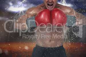 Composite image of aggressive boxer flexing muscles