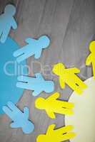 Blue and yellow paper cut out figures on wooden table