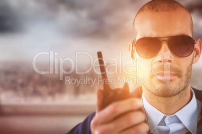 Composite image of portrait of security officer talking on walkie talkie