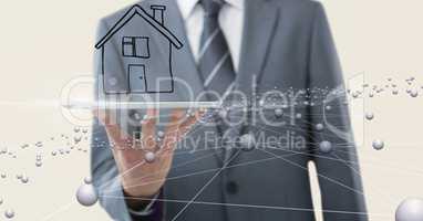 Midsection of businessman with house over mobile phone