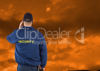Rear view of security guard against cloudy sky during sunset
