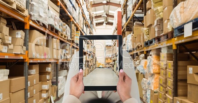 Person photographing warehouse through tablet PC