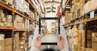 Person photographing warehouse through tablet PC