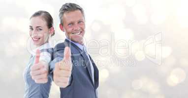 Portrait of happy business people showing thumbs up over bokeh