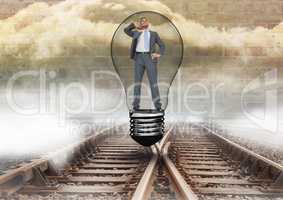 Businessman in light bulb over tracks