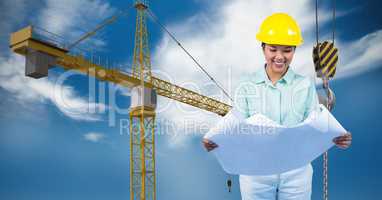 Female architect holding blueprint against crane