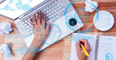 Hands using laptop and writing at desk with overlay