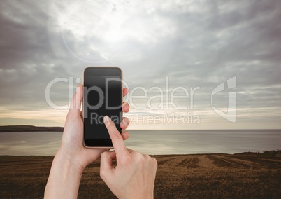 Hand Touching Mobile phone with evening sky landscape