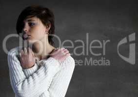 Woman with arms crossed against grey wall