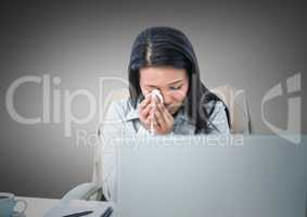 Woman crying at desk against grey background
