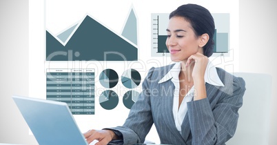 Confident businesswoman using laptop against graph background