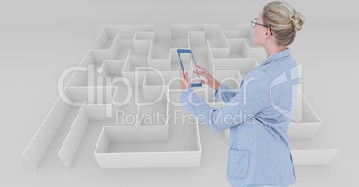 Businesswoman using tablet PC against maze
