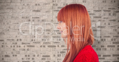 Redhead woman looking away against wall