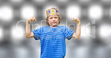 Portrait of confident boy in king crown flexing muscles over bokeh