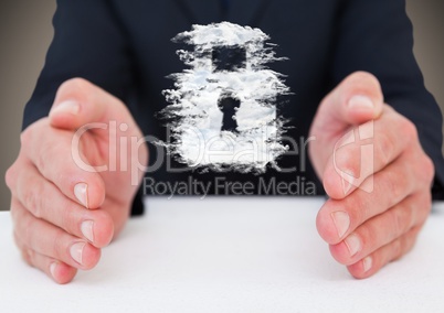 Business man at desk with cloud lock graphic between hands against brown background