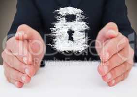 Business man at desk with cloud lock graphic between hands against brown background