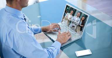 Midsection of businessman video conferencing with partners on laptop
