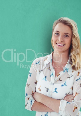 Portrait of confident businesswoman standing arms crossed against green background