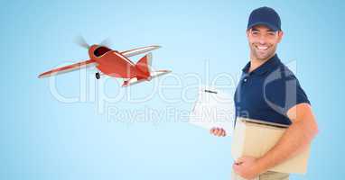 Delivery man carrying parcel against airplane