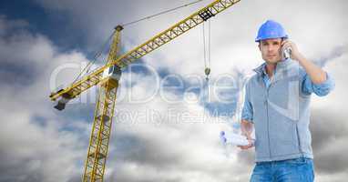 Architect using mobile phone against crane