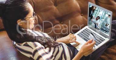 Businesswoman holding credit card while video conferencing at home