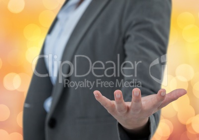Midsection of businesswoman offering hand over bokeh