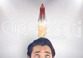 Businessman looking at rocket over head
