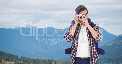 Male hiker photographing through camera on mountain