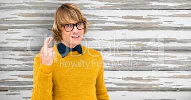 Portrait of male hipster crossing fingers against wooden wall