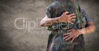 Back of soldier hugging against brown background with grunge overlay