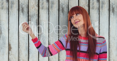 Redhead woman looking away against wooden wall